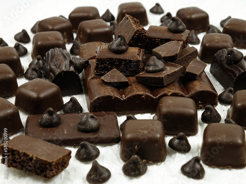 Assortment of milk and dark chocolate products on a wnite table, background photo