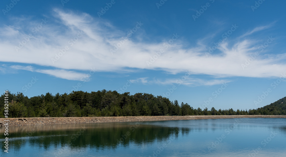 Panoramic view of dam full of water in the forest . Water reservoir