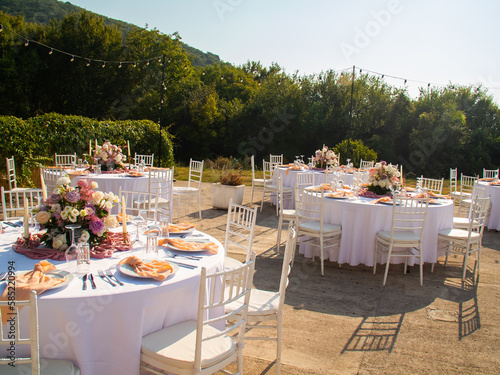 Table at luxury wedding reception event. Beautiful flowers on table and serving dishes and glasses and decoration
