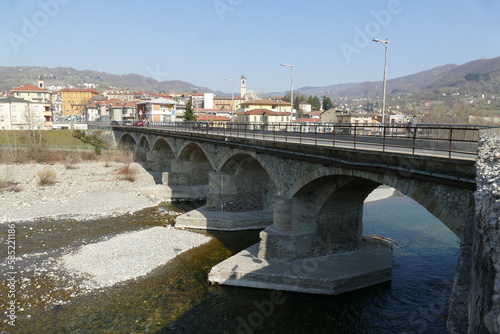 panorama of the village of Borgotaro with the arched bridge over the Taro river in the foreground and the hills in the background