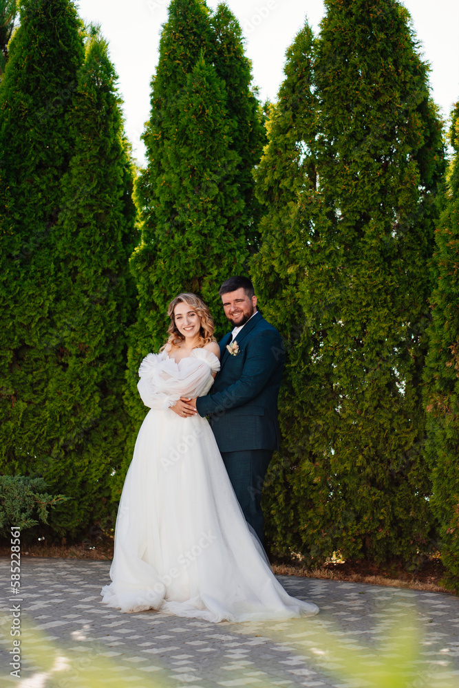 the bride and groom hugging and dancing in the park. 