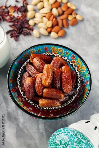 Dried dates and nuts on a gray background. Traditional iftar food and turkish lamp on concrete. Ramadan concept. Top view