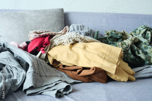 Messy clothes on sofa at home 