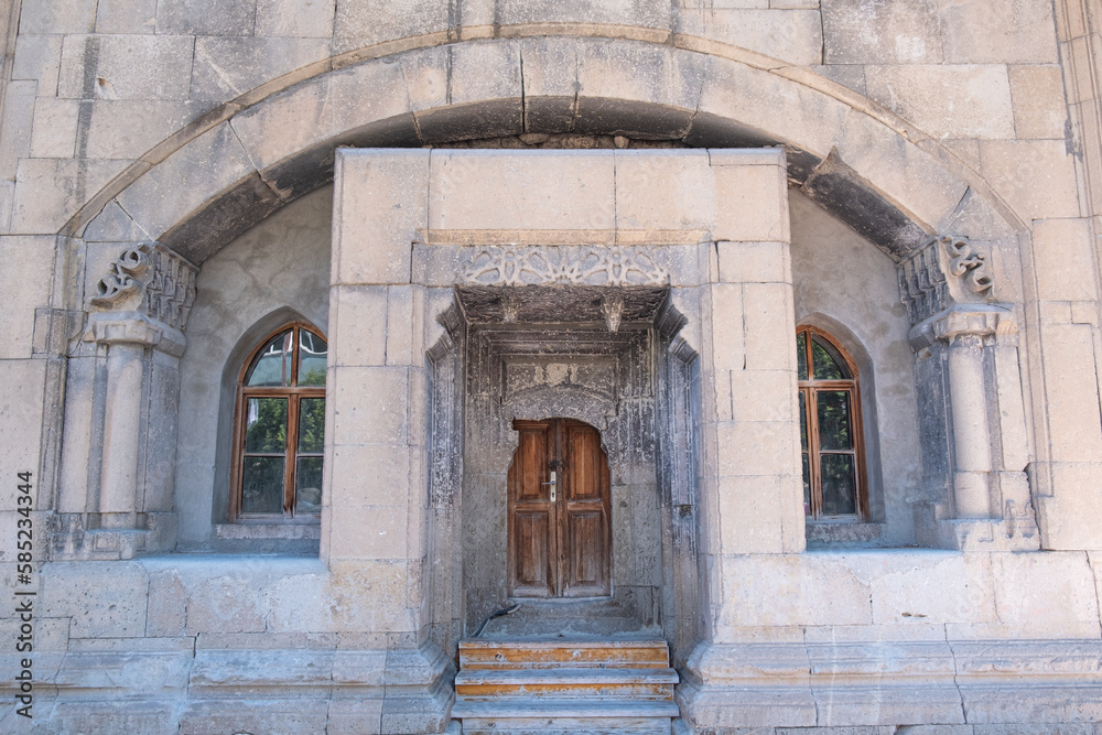 A building with decorative historical old stones and old carved wooden door. Museum of Amasya, Turkey