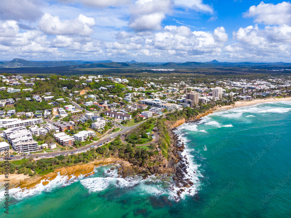Aerial, drone view of the spectacular Sunshine Coast city near Brisbane. Beautiful buildings on the cliffs and golden sand beaches at sunrise. Landscape of Queensland, Australia