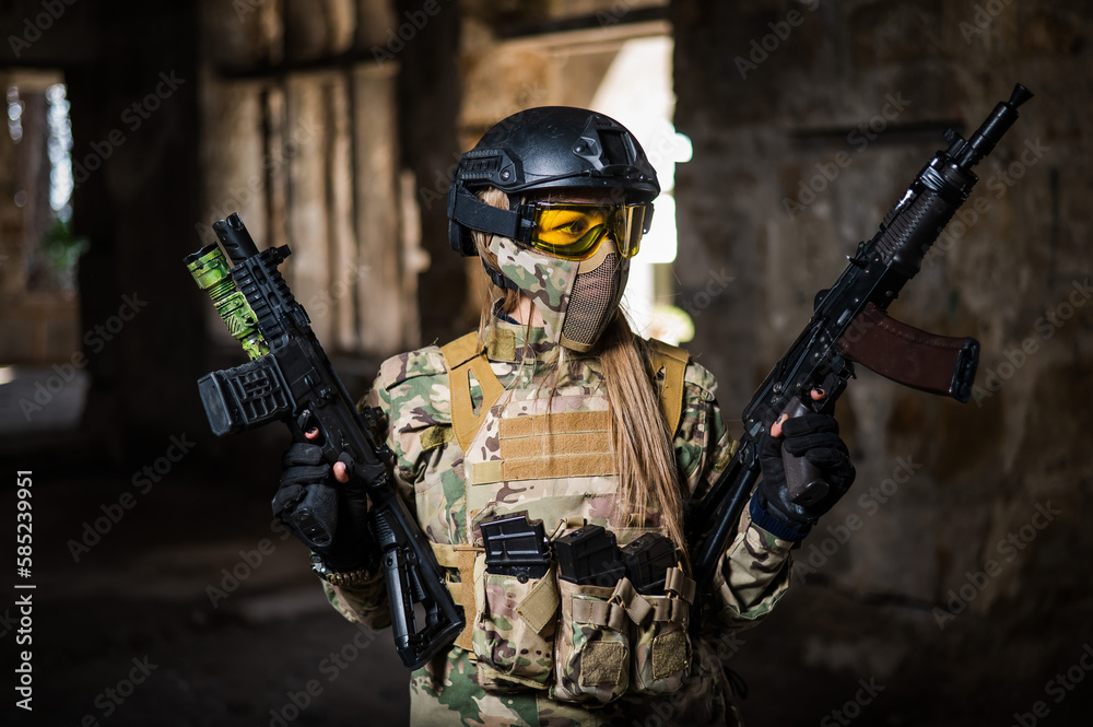 Fototapeta premium A woman in an army uniform holds a firearm in an abandoned building.