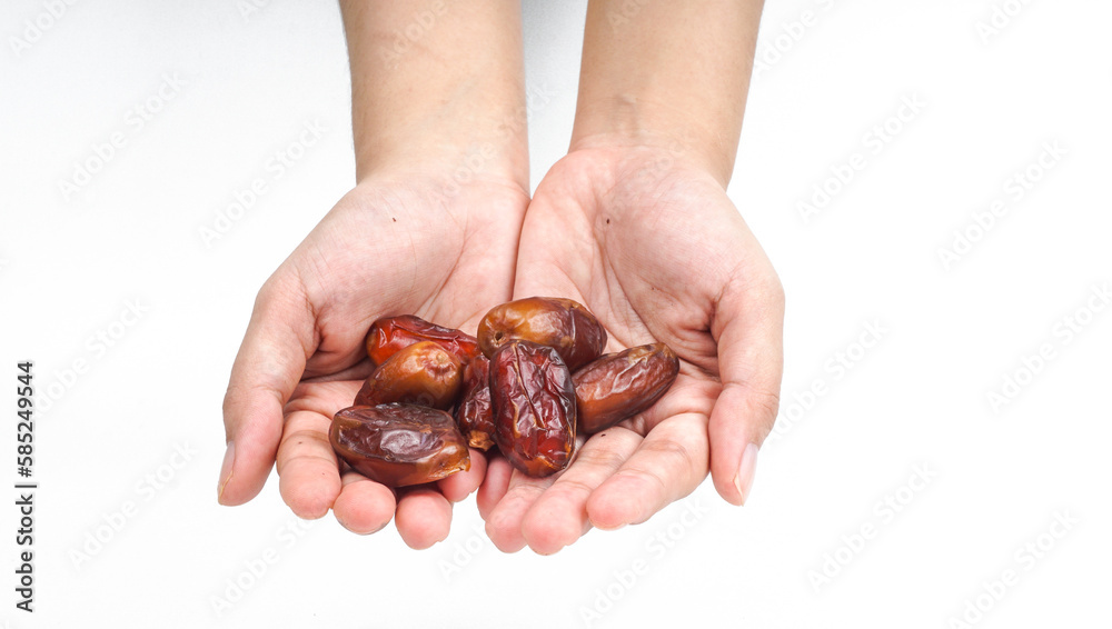 Woman's hand holding date palm fruits or Kurma. Ramadhan concept.