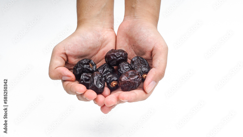 Dried dates fruit or Kurma hold by a hand on white background Dried dates fruit or Kurma hold by a hand on white background
