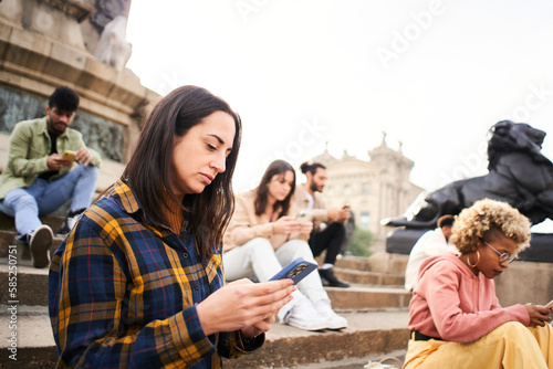 Obraz na płótnie Group of individualistic people using phone outdoors with serious face