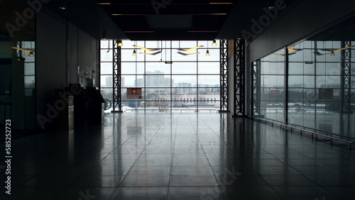 Large windows to floor in shopping center view from inside. Beautiful shiny floor in business center without people with cloudy light outside window.