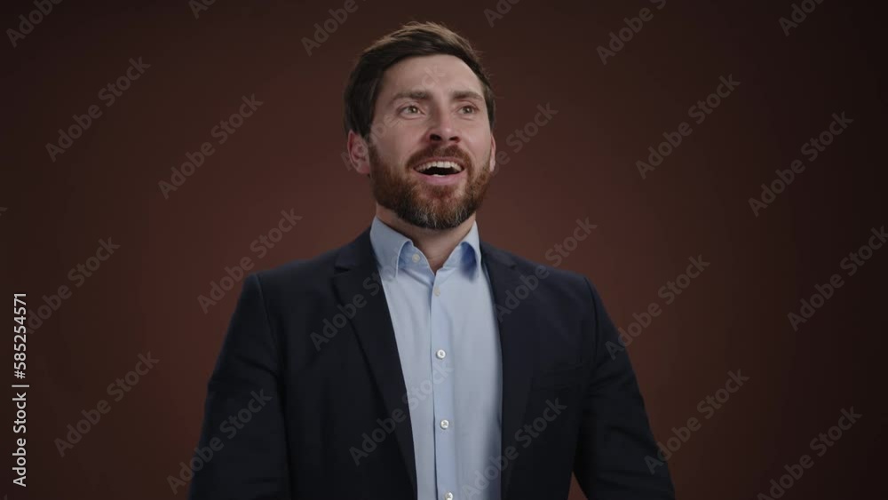A man in a suit taking off his protetive mask and exhaleing with a big smile. He is in a simple dark brown background. He looks pleased High quality 4k footage A man in a suit taking off his protetive mask and exhaleing with a big smile. He is in a simple dark brown background. He looks pleased High quality 4k footage