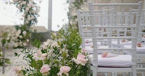 White chairs with bouquets and flower alley for wedding