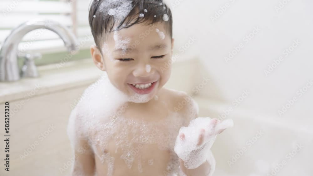 boy taking a bath in the tub take bath he plays with bubbles Stock ビデオ