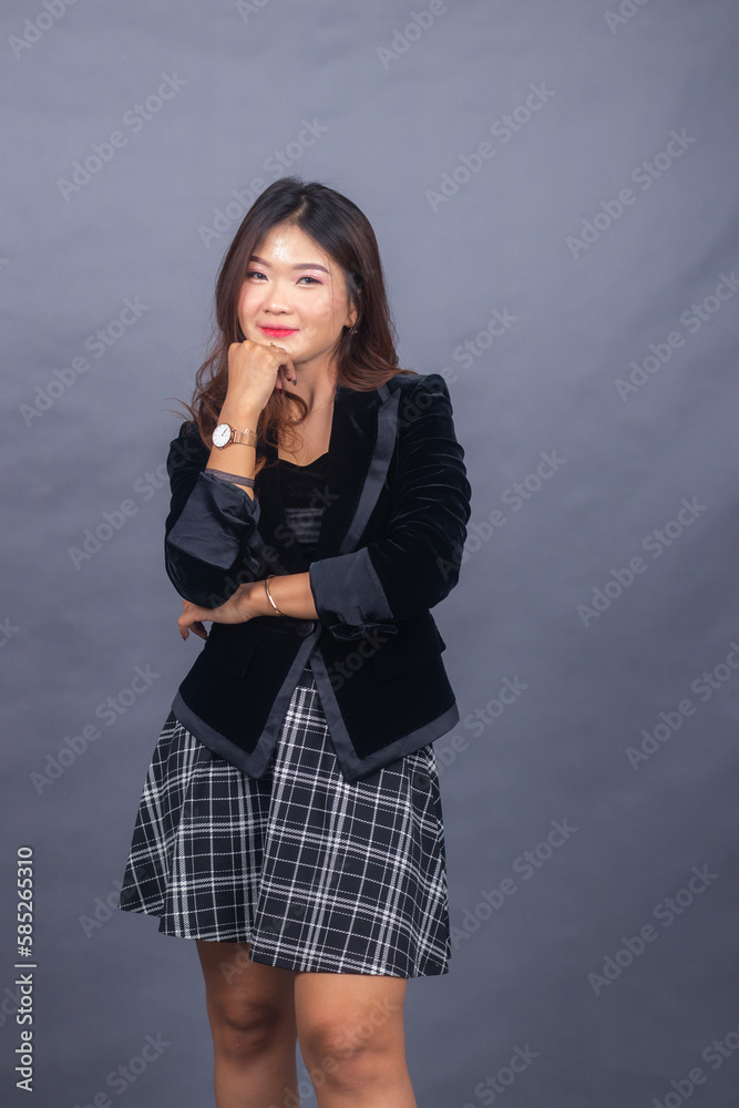 beautiful chinese asian women dressed in formal office wear jackets and skirts. girl expression smiling thin formal pose holding her hands tight and chin beautiful chinese asian women dressed in formal office wear jackets and skirts. girl expression smiling thin formal pose holding her hands tight and chin