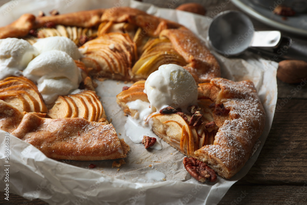 Delicious apple galette served with ice cream on wooden table, closeup