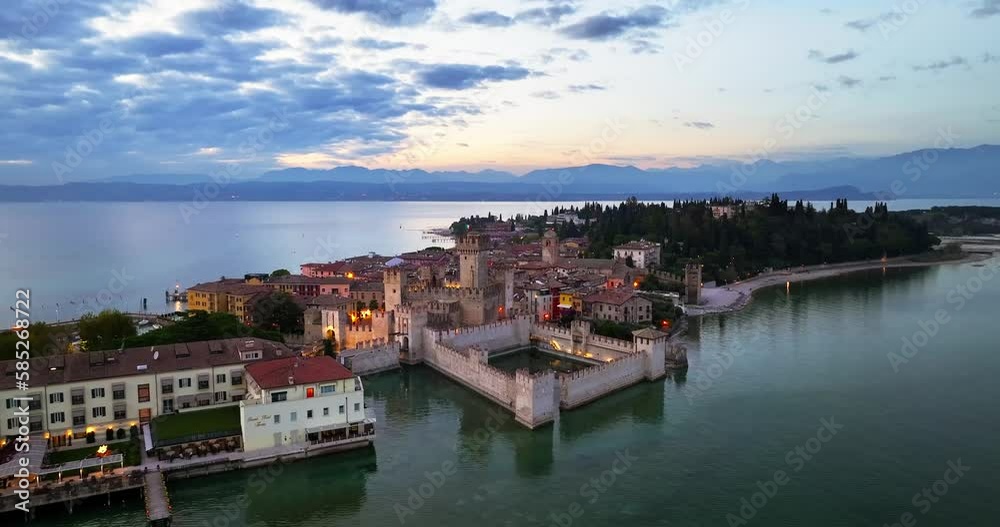 Aerial view of Scaligero Castle surrounded by crystal blue water Sirmione, Lake Garda, Italy Mountain Sunset Aerial view of Scaligero Castle surrounded by crystal blue water Sirmione, Lake Garda, Italy Mountain Sunset