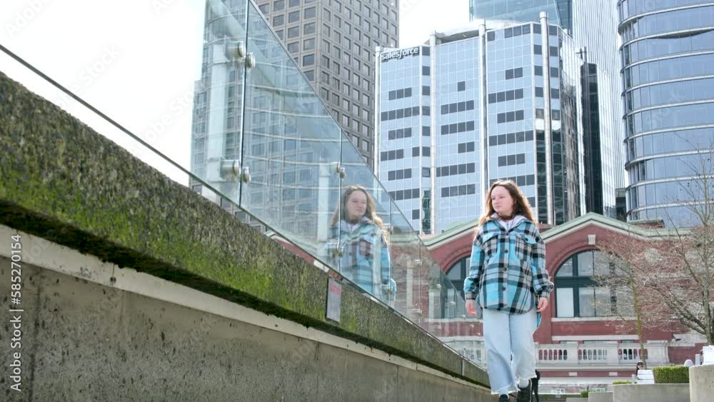 girl walks along the promenade near Canada Place in downtown Vancouver girl walks along the promenade near Canada Place in downtown Vancouver