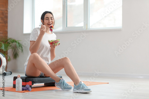 Sporty young woman eating v...