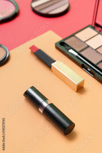 Lipsticks with eyeshadows on color background, closeup