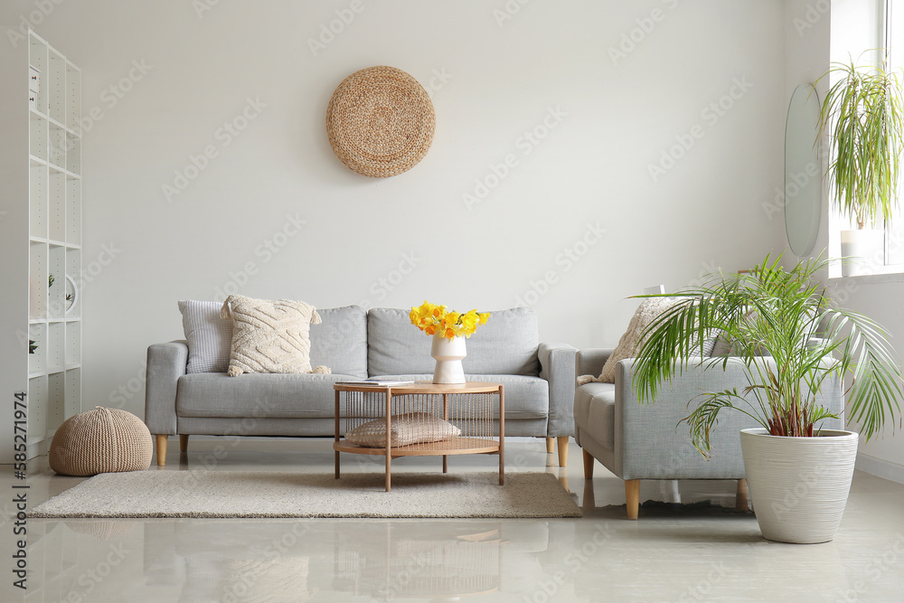 Interior of modern living room with cozy sofas and flower vase on