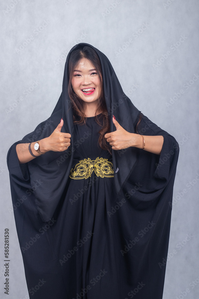 Asian chinese muslim headscarf hijab woman greeting ramadan fasting eid al fitr and eid al adha on white background. cheerful smiling expression girl hand giving thumbs up okay