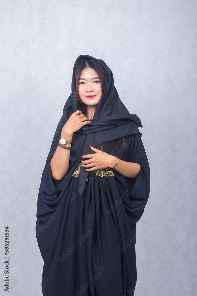 Asian chinese muslim headscarf hijab woman greeting ramadan fasting eid al fitr and eid al adha on white background. smiling expression of girl her hand holding a headscarf elegant