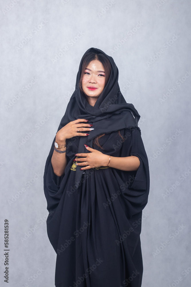 Asian chinese muslim headscarf hijab woman greeting ramadan fasting eid al fitr and eid al adha on white background. girl smiling expression her hand holding side hair