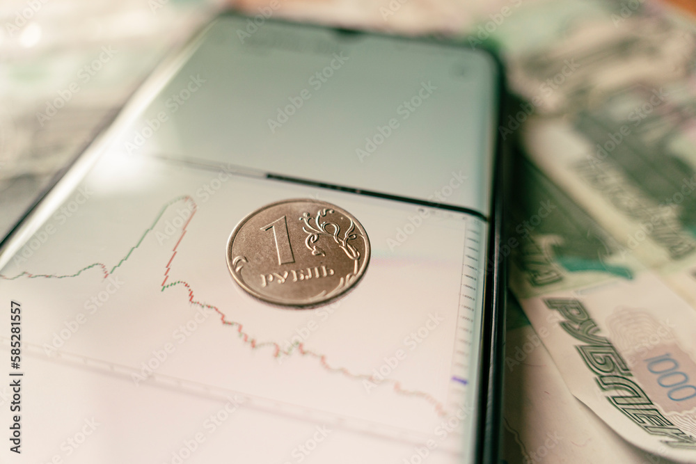 Economic crisis. Ruble devaluation. Russian currency. graph of sharp rise and fall of the ruble exchange rate on screen of a smartphone and coin one ruble. strengthening the growth of ruble Economic crisis. Ruble devaluation. Russian currency. graph of sharp rise and fall of the ruble exchange rate on screen of a smartphone and coin one ruble. strengthening the growth of ruble