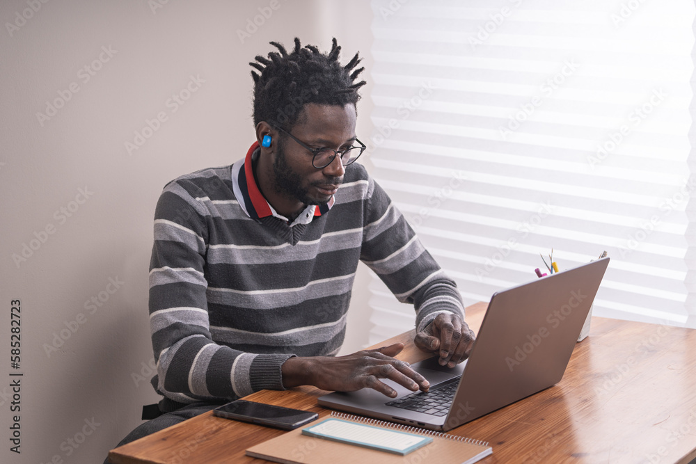 Multitasking African American student using keyboard and making a call Multitasking African American student using keyboard and making a call
