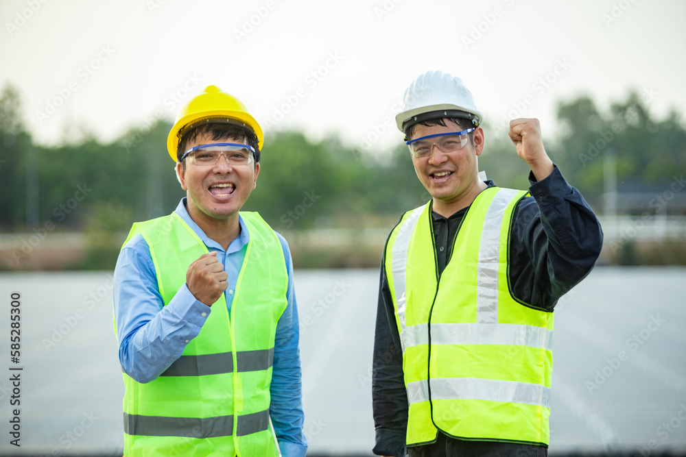 Asian engineer and technician on a solar power plant with success gesture. Asian engineer and technician on a solar power plant with success gesture.