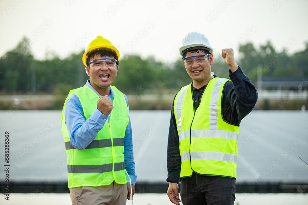 Asian engineer and technician on a solar power plant with success gesture. Asian engineer and technician on a solar power plant with success gesture.