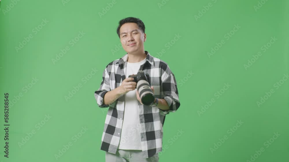 Asian Photographer Using A Camera Taking Pictures And Making Shh Gesture While Standing On Green Screen Background In The Studio
Asian Photographer Using A Camera Taking Pictures And Making Shh Gesture While Standing On Green Screen Background In The Studio