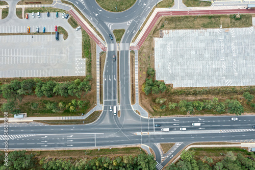 modern city infrastructure - traffic roundabout, road intersection, parking lots. aerial top view.