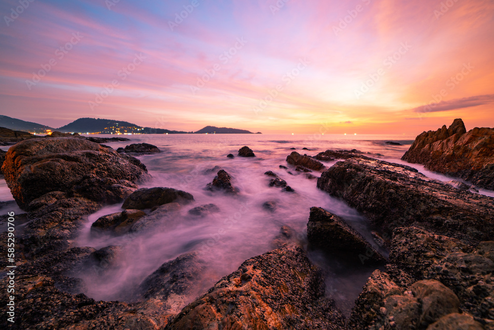 Long exposure image of Dramatic sky seascape with rock in sunset scenery background