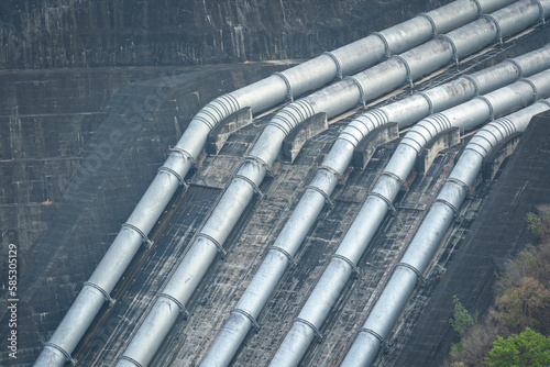 Huge metal pipeline structure on the electricity hydropower plant. Industrial and transportation equipment system object.  photo