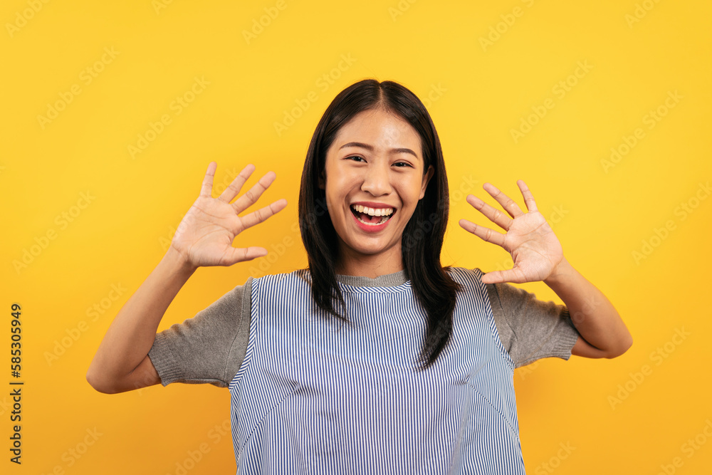 Young asian woman in casual clothes raising hands up with enjoyi Young asian woman in casual clothes raising hands up with enjoyi