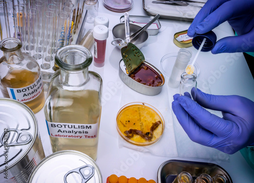 Experienced laboratory scientist analyzing a sample from a canned food can, botulism infection in sick people, conceptual image photo