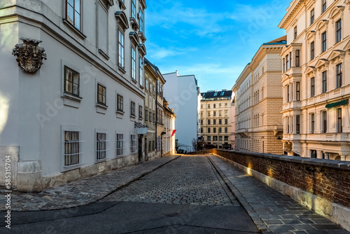 Narrow cobblestone street among historic buildings in Vienna.