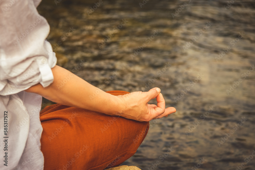 Woman doing yoga on the stone at the mountain river. Carpathians Woman doing yoga on the stone at the mountain river. Carpathians