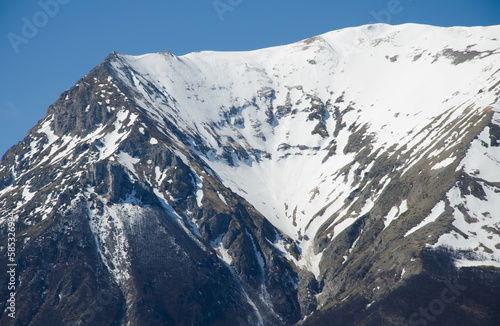 View of majestic peak of mount Vettore covered by snow in the Marghe region against the blue sky, Italy photo