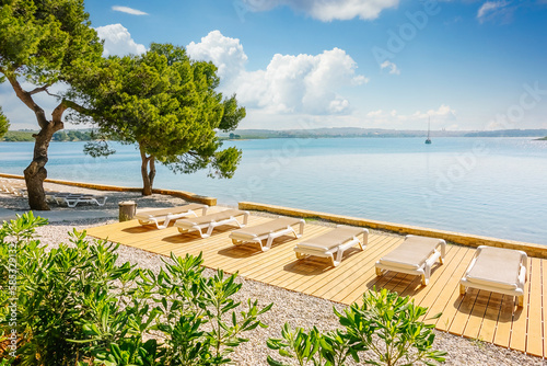 Fantastic view of the blue lagoon with empty sunbeds on the beach. Croatia  Europe.