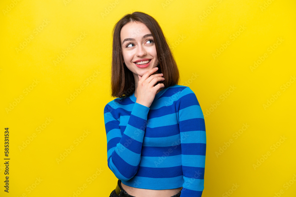 Young Ukrainian woman isolated on yellow background looking up while smiling Young Ukrainian woman isolated on yellow background looking up while smiling