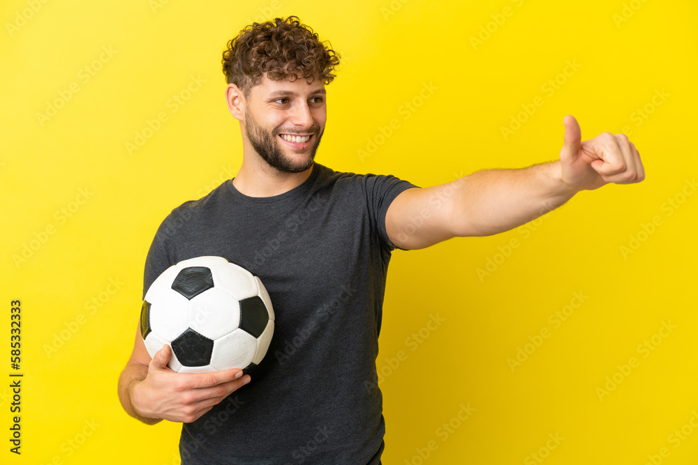 Handsome young football player man isolated on yellow background giving a thumbs up gesture Handsome young football player man isolated on yellow background giving a thumbs up gesture