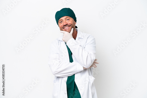 Middle age surgeon in green uniform isolated on white background smiling