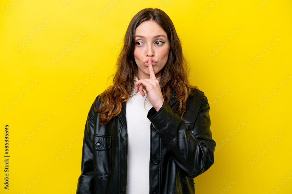 Young caucasian woman isolated on yellow background showing a sign of silence gesture putting finger in mouth Young caucasian woman isolated on yellow background showing a sign of silence gesture putting finger in mouth