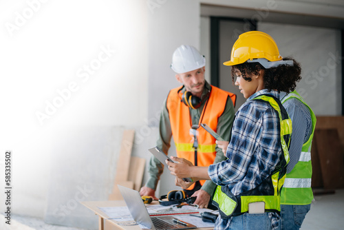 Architect caucasian man working with colleagues mixed race in the construction site. Architecture engineering on big project. Building in construction interior.