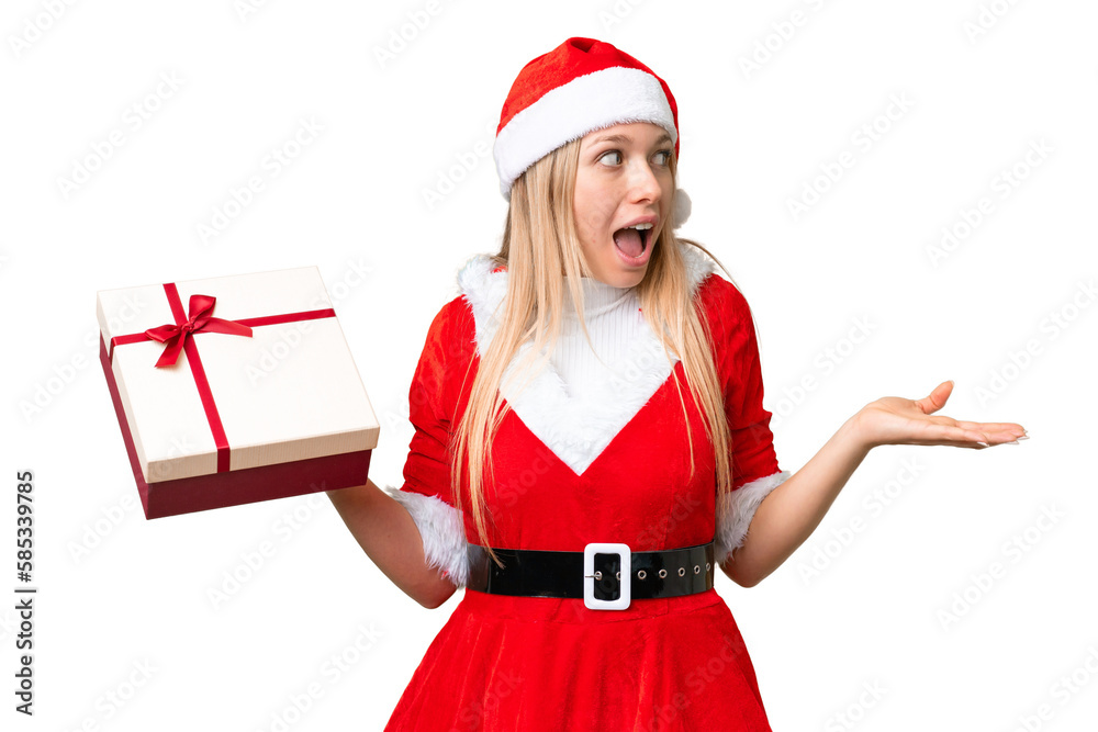 Young blonde woman with christmas hat and holding a gift over isolated chroma key background with surprise facial expression Young blonde woman with christmas hat and holding a gift over isolated chroma key background with surprise facial expression