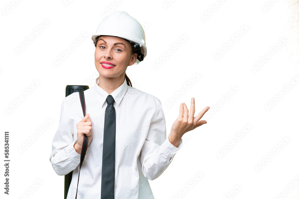 Young architect woman with helmet and holding blueprints over isolated background extending hands to the side for inviting to come Young architect woman with helmet and holding blueprints over isolated background extending hands to the side for inviting to come