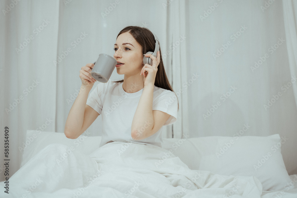 Beautiful girl at her bedroom drinking tea in the morning. Beautiful girl at her bedroom drinking tea in the morning.