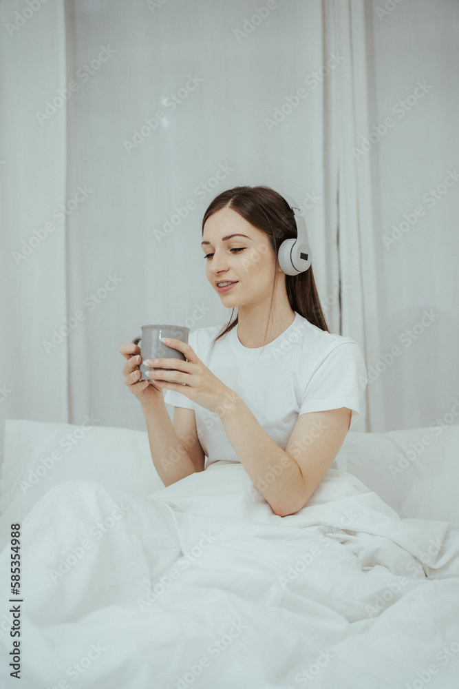 Beautiful girl at her bedroom drinking tea in the morning. Beautiful girl at her bedroom drinking tea in the morning.